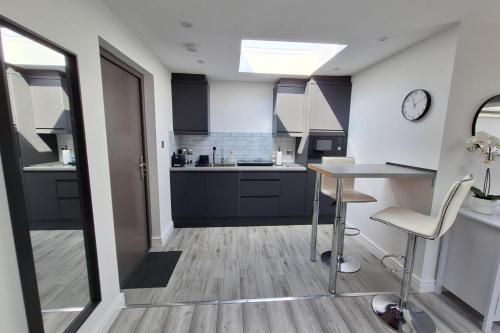 a kitchen with black cabinets and a table and chairs at Lodge - Sleeps 2 - Pet friendly - Parking - Patio in Sidcup