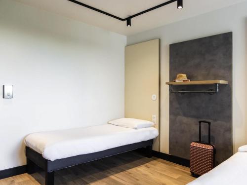 a small room with a bed and a wall at ibis Budget La Rochelle Centre gare in La Rochelle