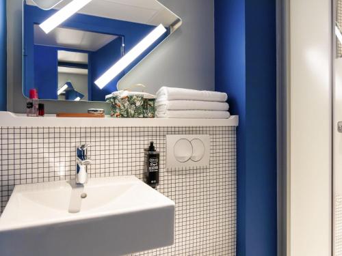 a bathroom with a white sink and a mirror at ibis Budget La Rochelle Centre gare in La Rochelle