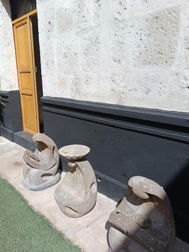 deux statues de pierre assises à côté d'un bâtiment dans l'établissement Barrio Sureño Hotel Boutique, à Arequipa