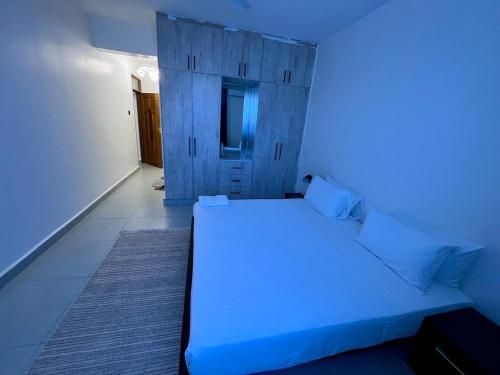 モンバサにあるCoastal haven apartmentのベッドルーム(青色のライト付きの白いベッド1台付)