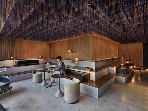 a man sitting at a table in a waiting room at Pullman Singapore Orchard in Singapore