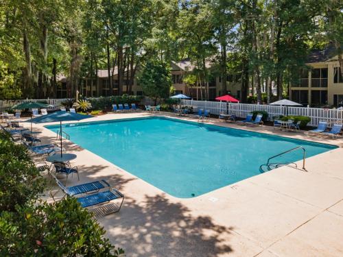 a large swimming pool with lounge chairs and umbrellas at Fairways & Ocean Breeze condo in Pawleys Island