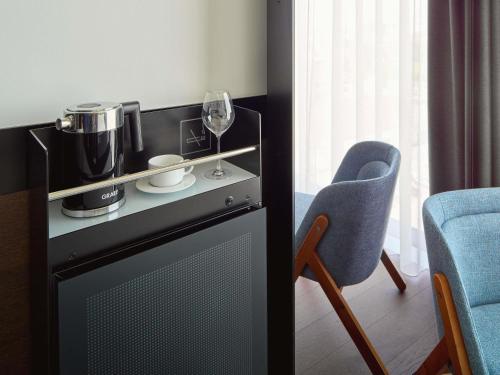 a kitchen with a blender and a glass of wine at Mövenpick Zagreb in Zagreb