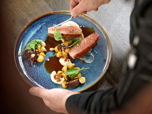 a person is eating a plate of food at Mövenpick Zagreb in Zagreb