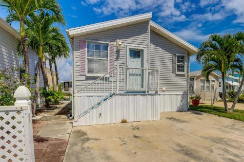 a house with a white fence and palm trees at Cozy Jensen Beach Home Pool Access, Walk to Beach in Jensen Beach