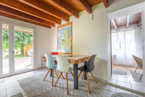 a dining room with a wooden table and chairs at Gîte à la campagne avec piscine in Biziat