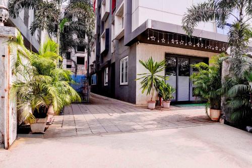 a building with palm trees in front of it at Collection O Navi Mumbai Formerly IVY Hotel in Mumbai