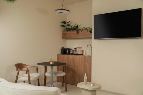 a living room with a table and a tv on a wall at Mode Eco Mood Hotel - Adults Friendly in Rimini