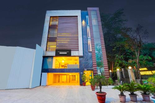 un edificio alto con le porte aperte e piante in vaso di Townhouse South Delhi a Nuova Delhi