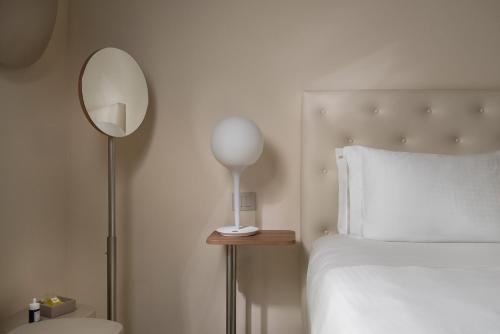 a bedroom with a bed and a mirror and a lamp at Mode Eco Mood Hotel - Adults Friendly in Rimini