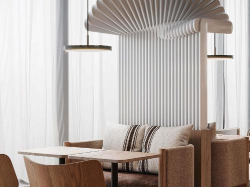 a dining room with a table and a couch at Mercure Hotel Delémont in Delémont