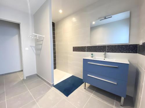 a bathroom with a blue sink and a mirror at Ty Cath - Maison en bord de mer in Guissény