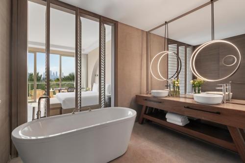 a bathroom with a tub and two sinks at Rixos The Palm Hotel & Suites - Ultra All Inclusive in Dubai