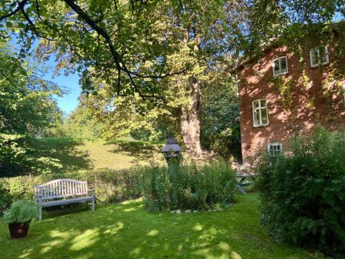 a bench in the yard of an old brick house at Ferienhaus NATURlich Wassermuhle in Kappeln
