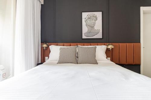 a bedroom with a large white bed with two pillows at Iconyc Charlie Ibirapuera Hotel in Sao Paulo