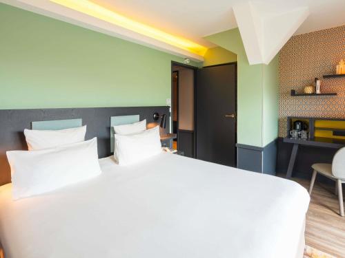 a bedroom with a large bed with white pillows at Le Splendid Hotel Lac D'Annecy - Handwritten Collection in Annecy