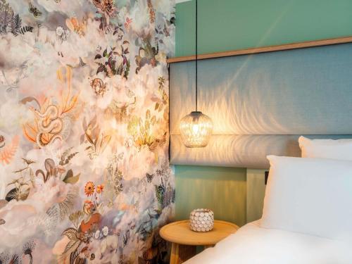 a bedroom with a bed and a floral wallpaper at Le Splendid Hotel Lac D'Annecy - Handwritten Collection in Annecy