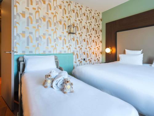 two beds in a hotel room with two teddy bears at Le Splendid Hotel Lac D'Annecy - Handwritten Collection in Annecy