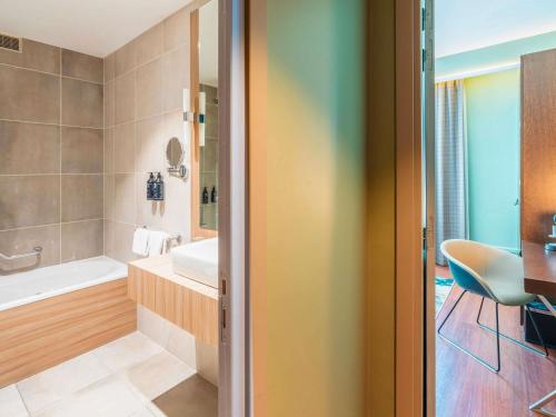 a bathroom with a tub and a sink at Le Splendid Hotel Lac D'Annecy - Handwritten Collection in Annecy