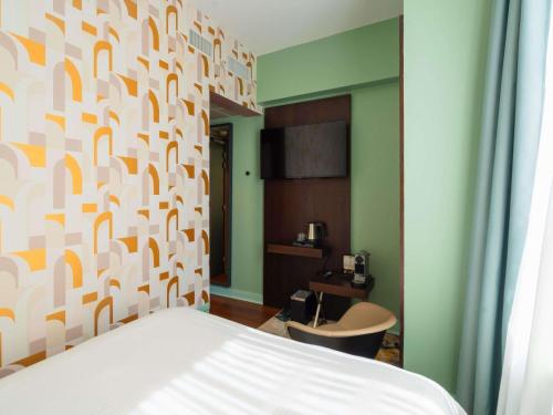 a bedroom with a bed and a wall with orange and white at Le Splendid Hotel Lac D'Annecy - Handwritten Collection in Annecy