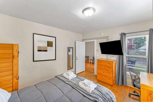 a bedroom with a bed and a flat screen tv at Right Field All Star Baseball Rentals in Oneonta