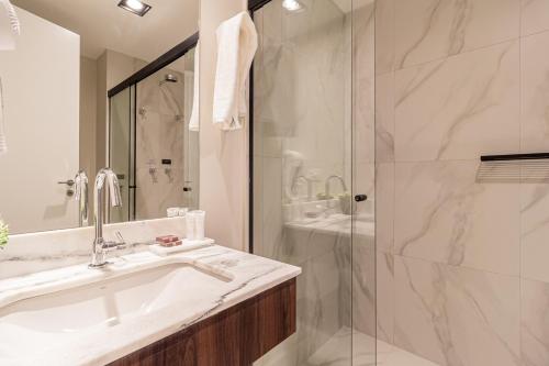 a bathroom with a sink and a shower at Iconyc Charlie Ibirapuera Hotel in Sao Paulo