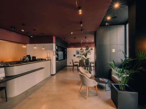 a lobby with a counter and chairs and a bar at Aparthotel Adagio Malta Central in Msida
