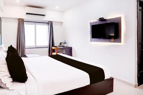 a bedroom with a bed with a tv on the wall at Collection O Navi Mumbai Formerly IVY Hotel in Mumbai