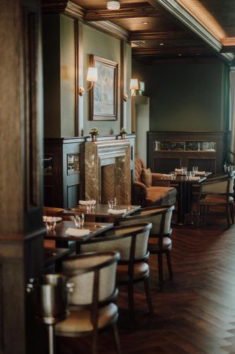 a restaurant with tables and chairs in a room at Dunluce Lodge - Small Luxury Hotels of the World in Portrush
