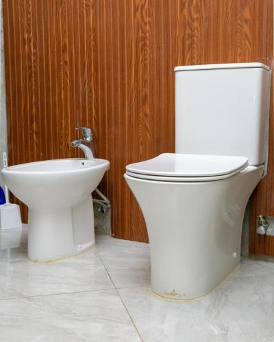 a white toilet and a bidet in a bathroom at Couzy stylish stays 3 Bdrm Watamu with Beach access in Watamu