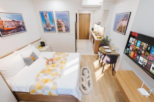 a bedroom with a large bed and a small table at Margaery Boutique Apartment & Skyon9 Rooftop Bar in Hanoi