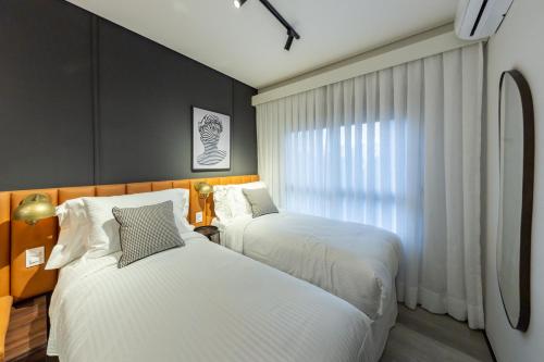 a bedroom with two beds and a window at Iconyc Charlie Ibirapuera Hotel in Sao Paulo