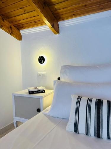 a bedroom with a white bed with a night stand at Paradises's Nest in Agios Georgios