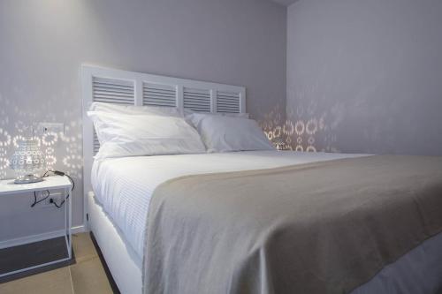 a bedroom with a white bed with a white headboard at Manè Boutique Hotel in Roseto degli Abruzzi