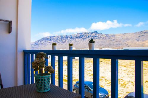 a table on a balcony with a view of the mountains at El Arenal de Famara by Escape Home in Famara