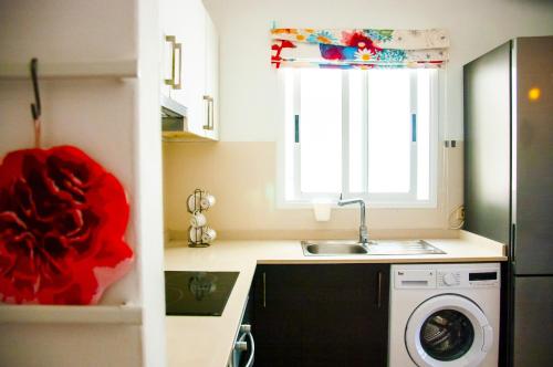 a kitchen with a sink and a washing machine at El Arenal de Famara by Escape Home in Famara