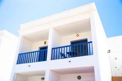 a white apartment building with blue balconies at El Arenal de Famara by Escape Home in Famara