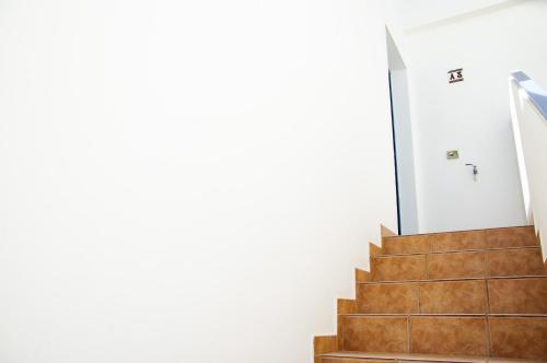 a staircase in a house with white walls and wooden stairs at El Arenal de Famara by Escape Home in Famara