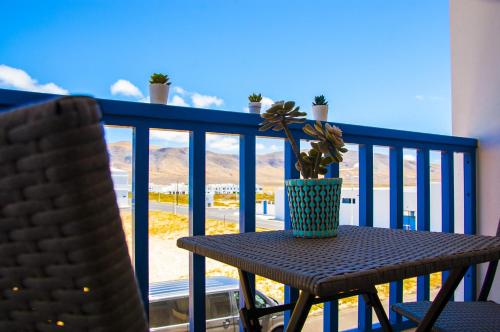 a table and chairs on a balcony with a potted plant at El Arenal de Famara by Escape Home in Famara