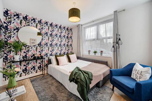 a bedroom with a bed and a mirror and a chair at Edegely House in Stockport