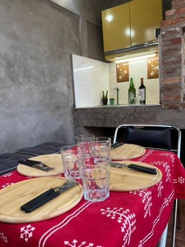 a table with plates and glasses on a red table cloth at Morada Romana in Rivadavia