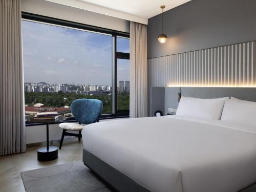 a bedroom with a bed and a desk and a window at Mondrian Seoul Itaewon in Seoul