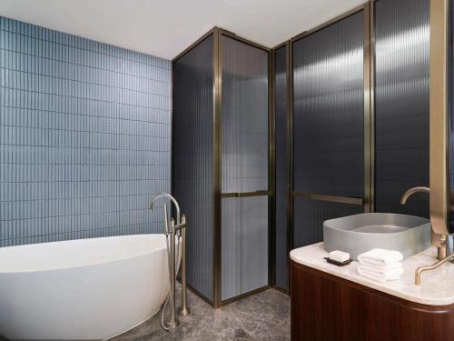 a bathroom with a bath tub and a sink at Mondrian Seoul Itaewon in Seoul