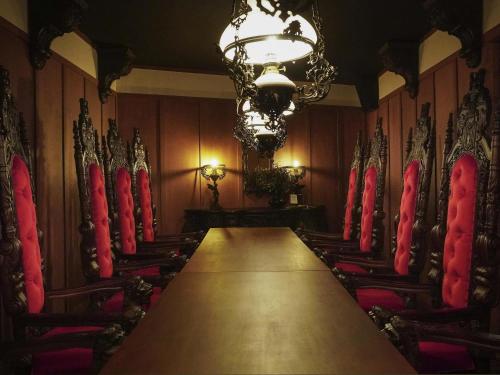 a dining room with a long table and red chairs at Mondrian Seoul Itaewon in Seoul