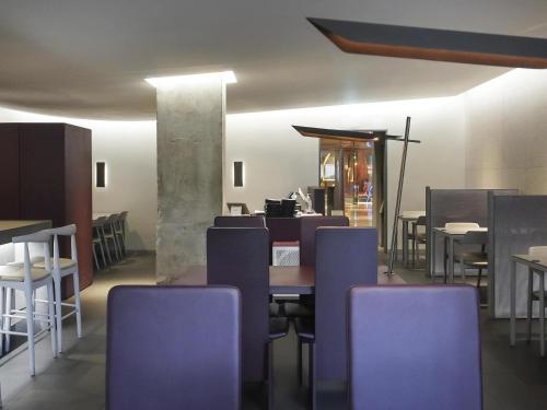 a dining room with a table and purple chairs at Mondrian Seoul Itaewon in Seoul