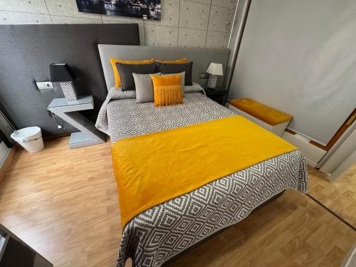 a bedroom with a large bed with a yellow blanket at GRAN CASTRAVINARIA in Lucena