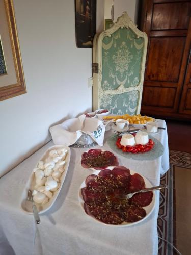 a table with a white table cloth with food on it at Tuscany Villa Gorello. Villa in Toscana. Jacuzzi con tetto in cristallo,piscina in Arezzo