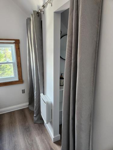 a room with gray curtains and a window at Chalet Lac Édouard cozy in La Tuque