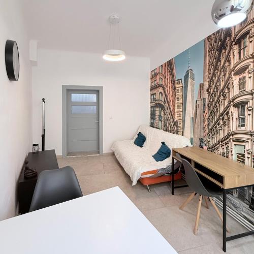a living room with a bed and a desk at Apartment near Central Park with garden view in Cluj-Napoca